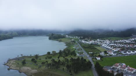 aerial establishing shot of lagoa verde and nearby village in the azores