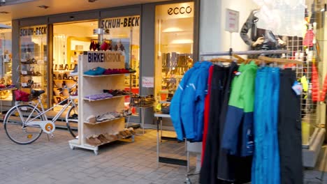 woman walking in front of a shoe store in a european city