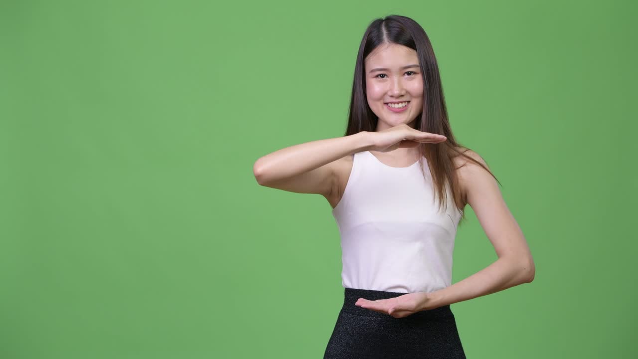아름다운 젊은 아시아 사업가 여성이 무언가를 보여주고 있습니다.