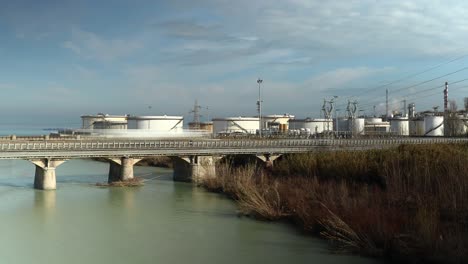 Imágenes-De-Timelapse-Del-Tráfico-En-El-Puente-Frente-A-Una-Refinería-De-Combustible-Cerca-Del-Mar,-Concepto-De-Contaminación
