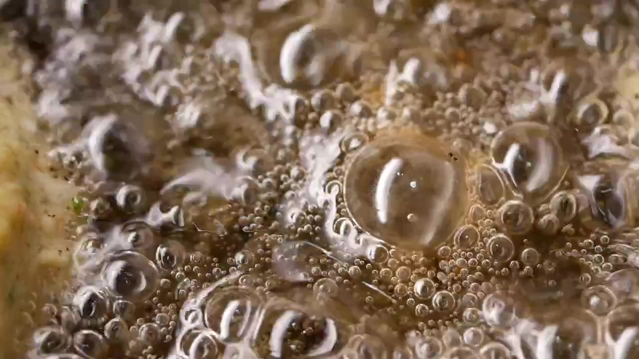 Primo piano di cibo che frigge nell'olio bollente