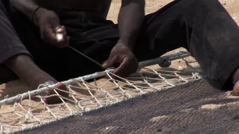 Fisherman-repairs-fish-net