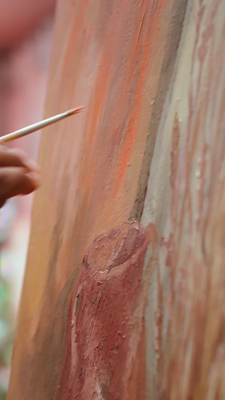 Close-Up of Artist's Hand Painting on Canvas with a Brush