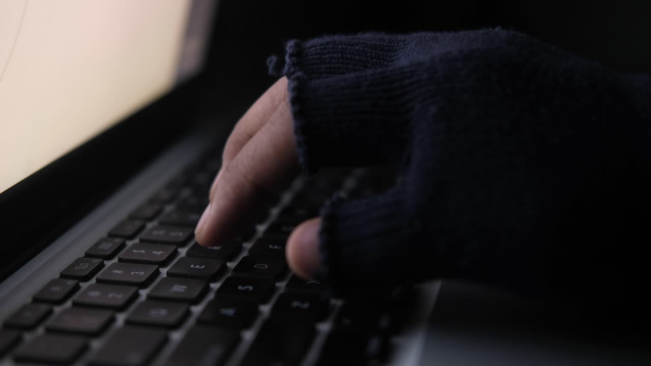 Hacker Typing on Laptop at Night