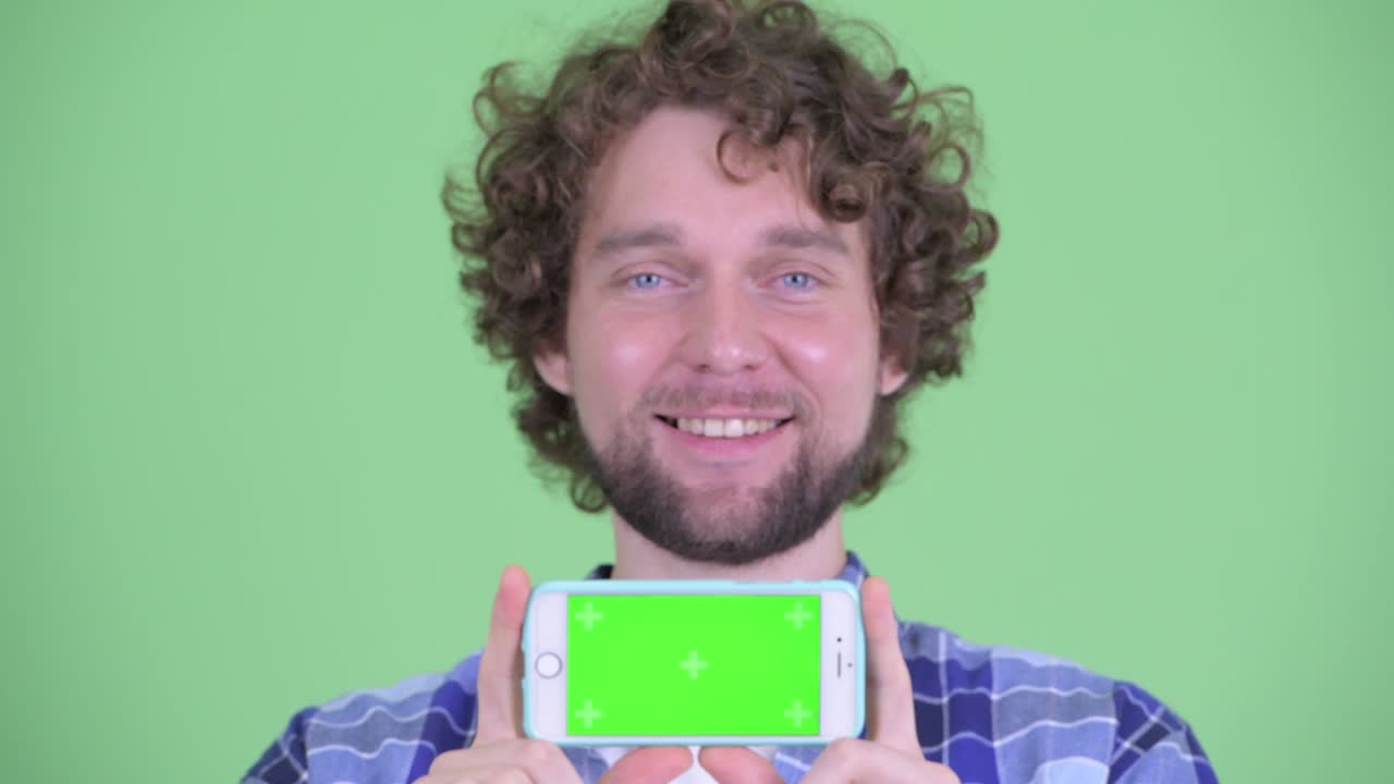 Young handsome bearded hipster man with curly hair