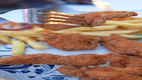 closeup of crispy fried chicken strips with french fries