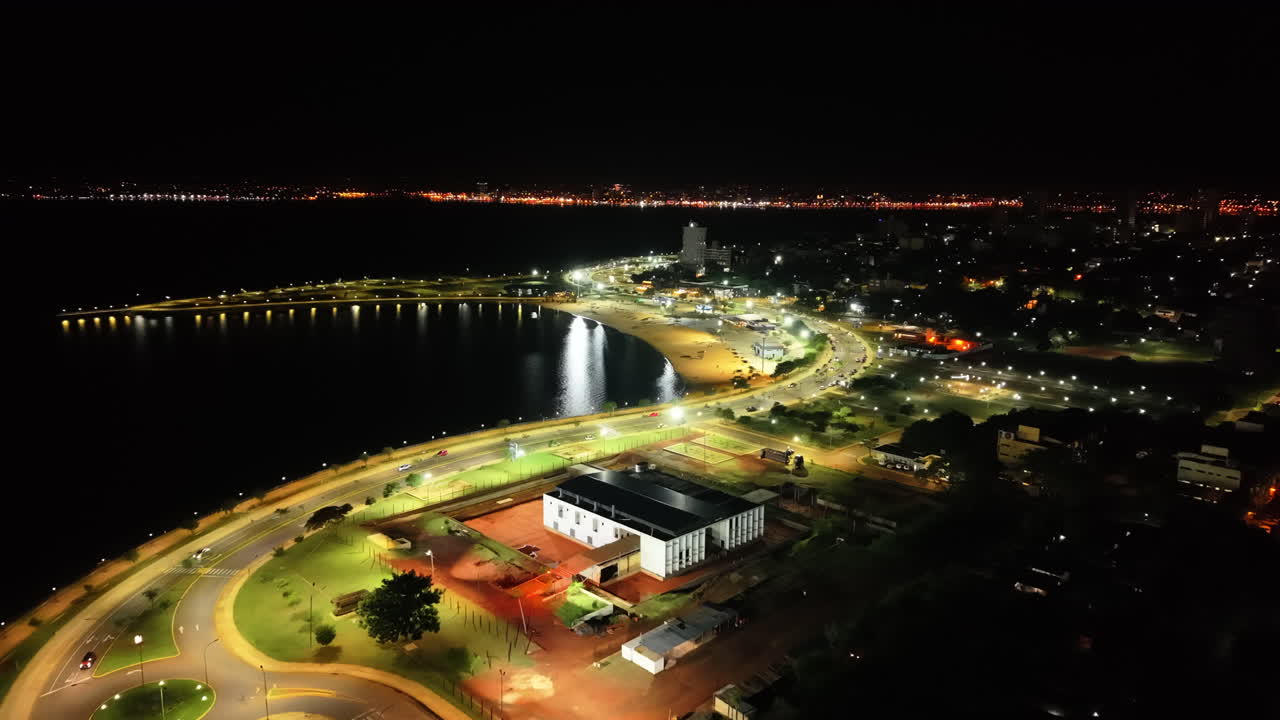 Aerial view of brightly illuminated Bahia El Brete beachside area at night in Posadas city, Misiones, Argentina.