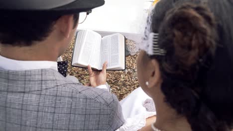 view behind a couple reading holy bible during their wedding ceremony