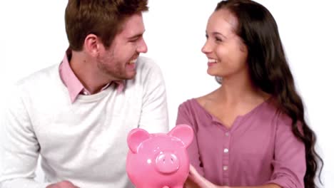 cute couple with moving box and piggy bank
