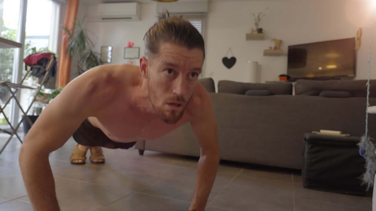 el hombre masculino está haciendo flexiones en el entorno doméstico, la disciplina y el principio de entrenamiento, la aptitud y el mantenimiento de la salud