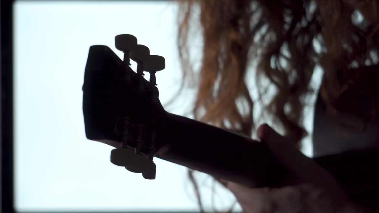 Close up, dramatic style Long Red Haired man Playing acoustic guitar silhouette white light background