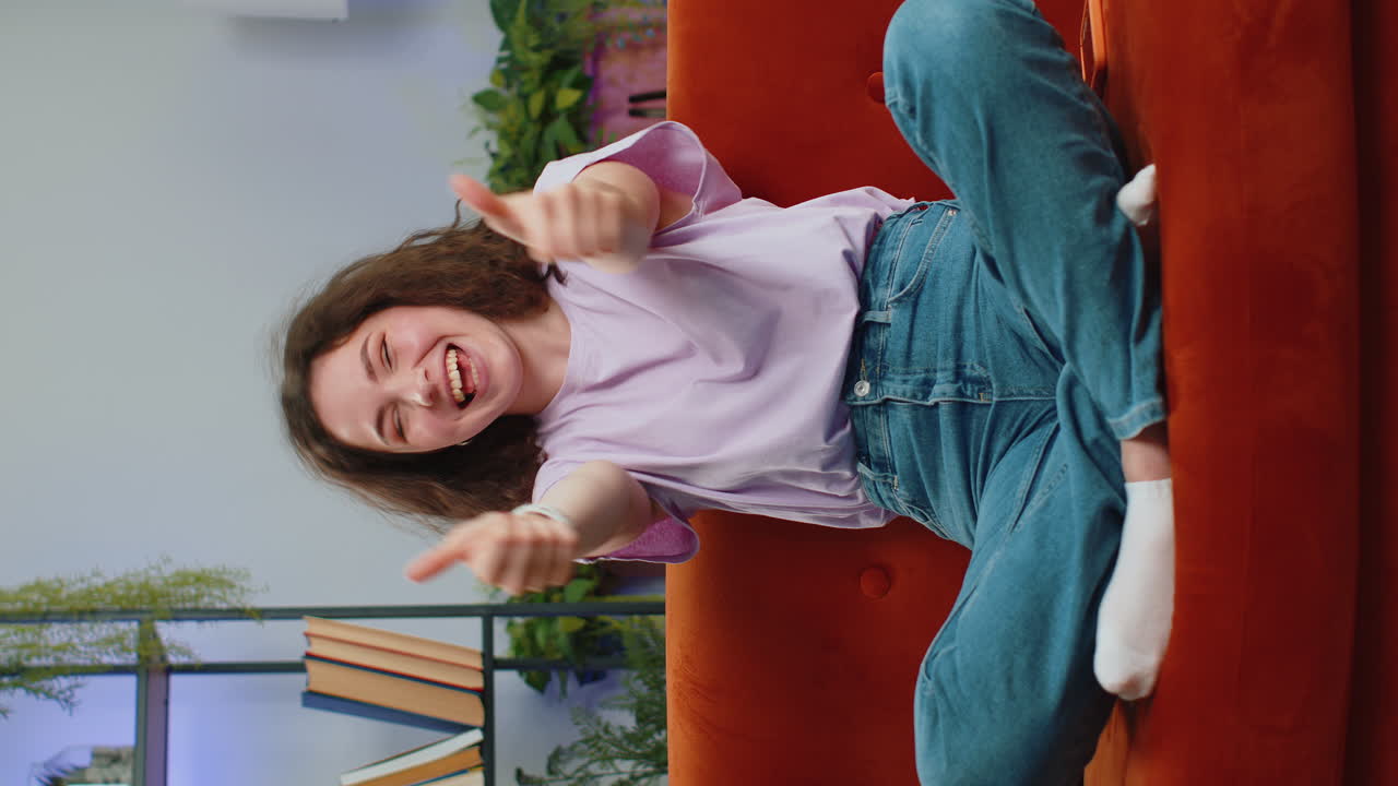 Happy young woman looking approvingly at camera showing thumbs up, like positive sign, good news