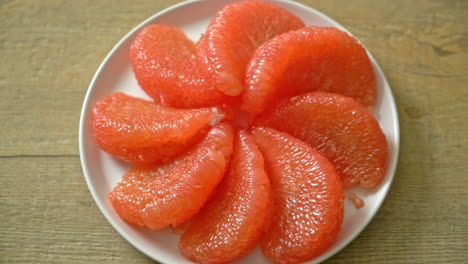 fresh red pomelo fruit or grapefruit on plate