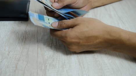 man counting  rupiah notes