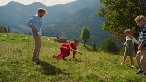 parents playing outdoor games with children on mountain slope. family have fun.