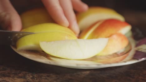 Hände-Schneiden-Frischen-Apfel-In-Einem-Teller-Mit-Einem-Schälmesser