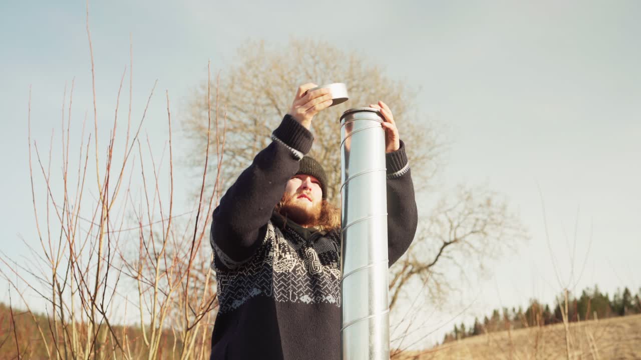 The Man Raises the Chimney Lid of the DIY Hot Tub - Static Shot