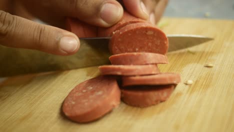 cortar el salami en una tabla de cortar