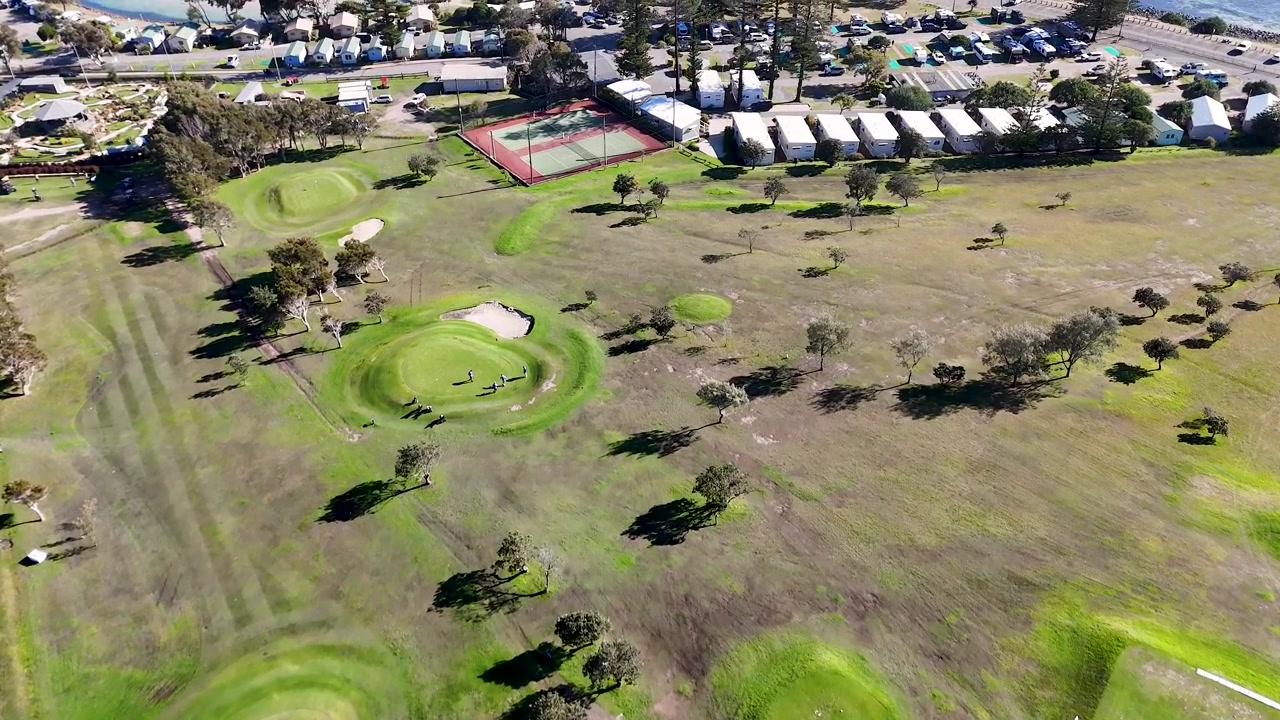 Ripresa aerea con drone dall'alto su un green lussureggiante di un campo da golf a Crescent Head, Australia.