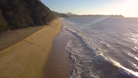 drone ascend over long paradise beach