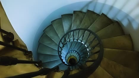 looking out from the iron balustrade of an ancient spiral staircase and looking down towards the center of the spiral