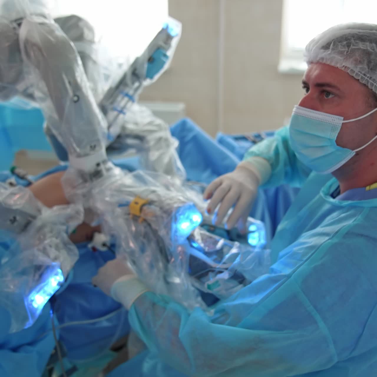 Surgeon applying modern technological equipment to a patient. Robotic arms assisting the doctor in his work. Innovative equipment in a surgery