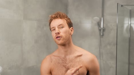 hombre atlético con el torso desnudo usa perfume en el cuerpo