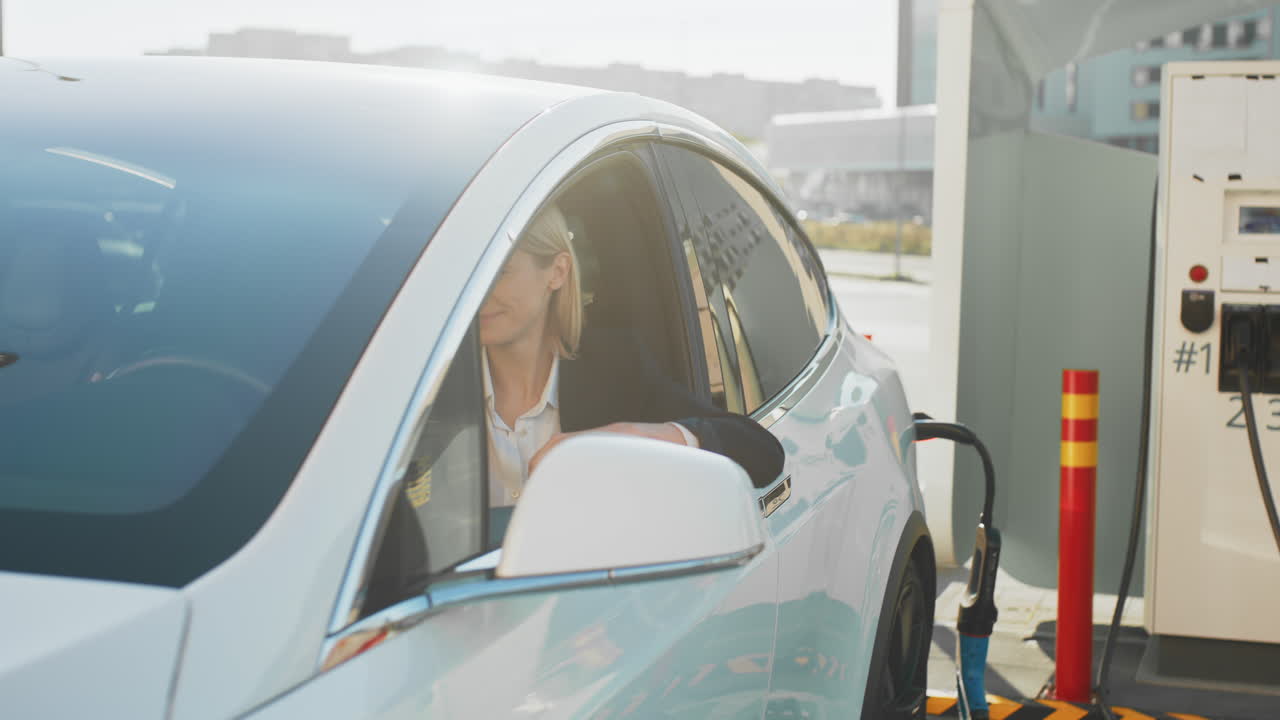 충전소 에서 전기 자동차 를 운전 하는 여자