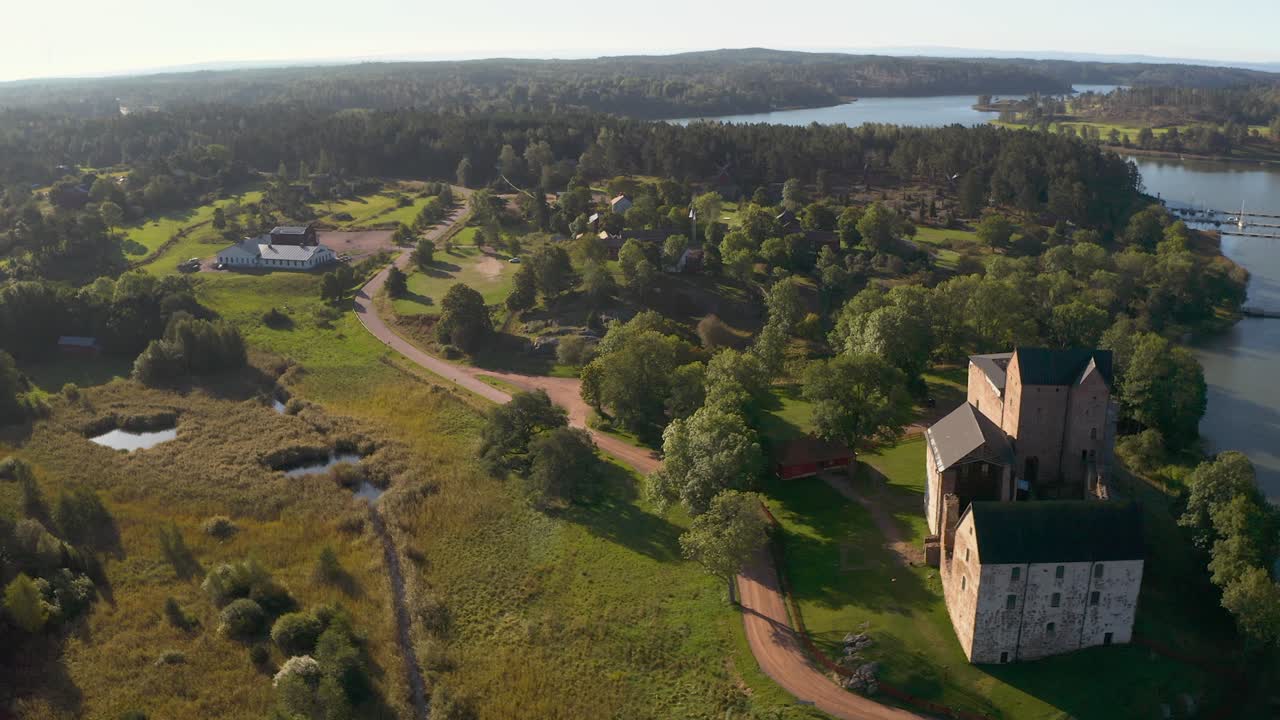Aerial tracking shot of a restaurant, road and the Kastelholma castle in Aland