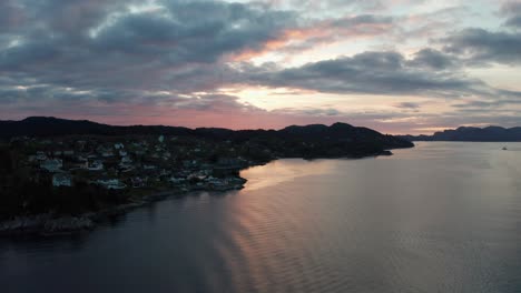 the town of klokkarvik, island sotra outside bergen - late night dawn with dark foreground and red sunset skies - seen from leroyosen sea