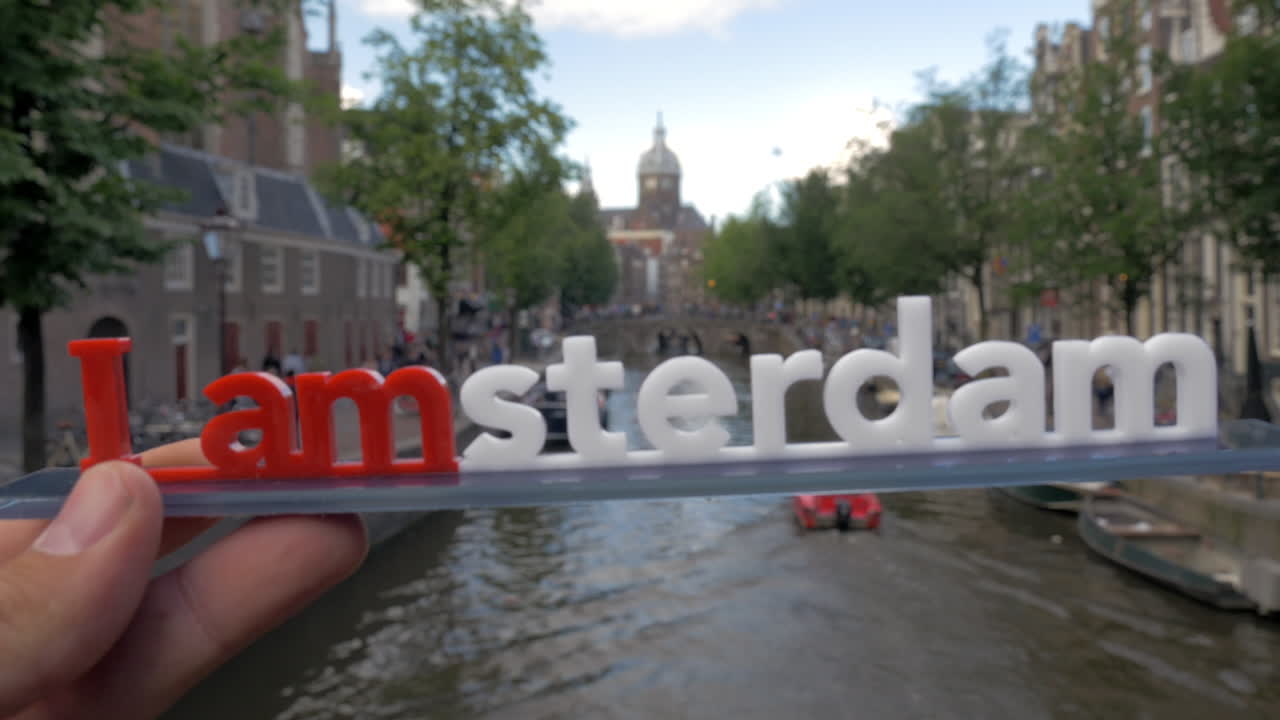 Amsterdam slogan and city view with canal