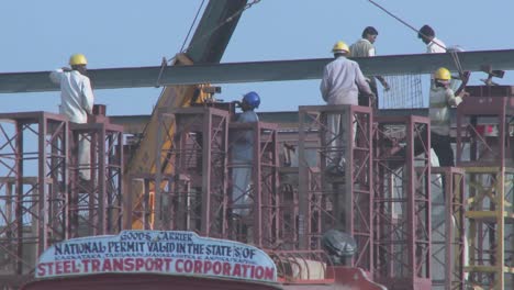 widening view of construction workers and the traffic and vehicles traveling on the streets