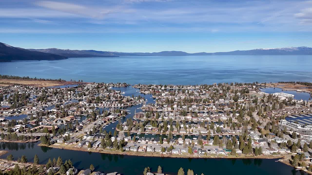 Aerial view of Lake Valley Village residential community with pond and pine forest