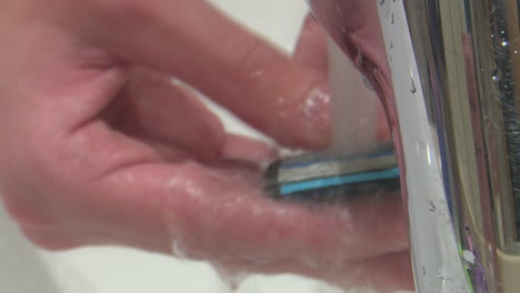Washing a Razor Under a Faucet