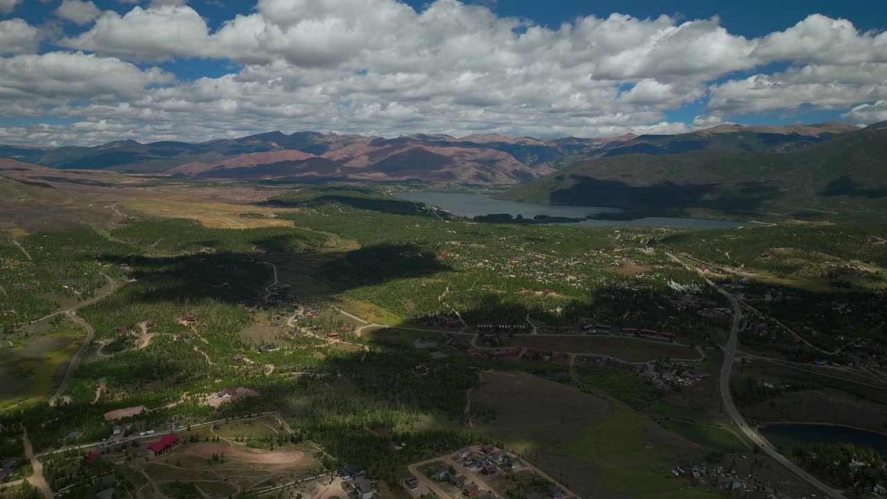 avión no tripulado cinematográfico de alta altitud gran lago sombra montaña abuelo colorado montaña rocosa entrada del parque nacional tranquilo claro hermosa mañana de verano paseo en bote picos de bosque con nieve derretirse hacia adelante