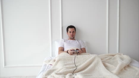hombre jugando videojuegos en la cama