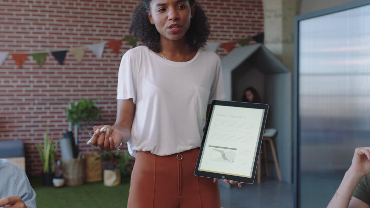 young business people meeting team leader woman presenting financial data using tablet computer showing multi ethnic colleagues marketing ideas in office boardroom presentation