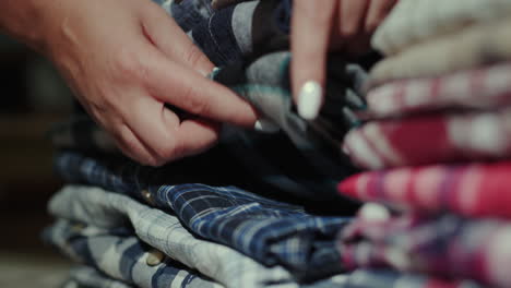 Women's-hands-sort-through-a-stack-of-men's-shirts-5