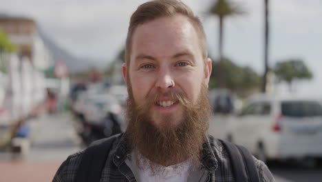 retrato de un hombre hipster barbudo sonriendo feliz mirando a la cámara disfrutando de las vacaciones de estilo de vida de verano en la soleada ciudad urbana frente a la playa