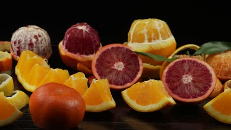 frutas cítricas, cortadas en rodajas decorativas, en una mesa de madera negra.