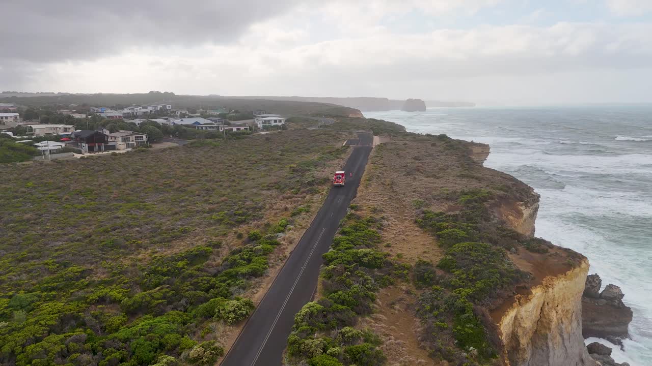 Aerial view of a fire engine on a coastal road near Port Campbell, showcasing dramatic cliffs and ocean scenery