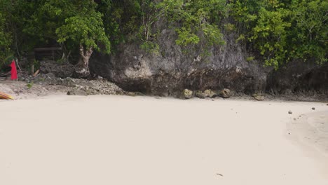 White-Sandy-Seashore-With-Waving-Red-Flag-On-The-Beach-In-Southern-Leyte,-Philippines