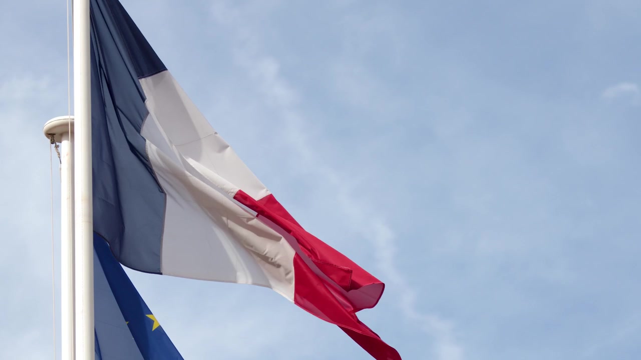 La bandiera nazionale francese tricolore sventola contro un cielo azzurro a Cassis, Francia