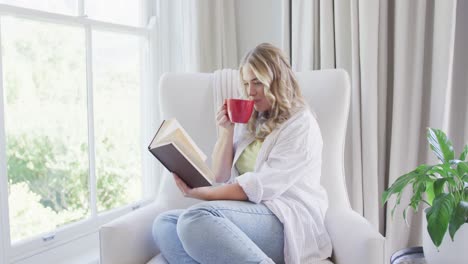 retrato de una feliz mujer caucásica de tamaño grande leyendo un libro y bebiendo café en cámara lenta.