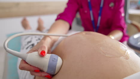 obstetrician examining pregnant belly by ultrasound scan. process of fetal ultrasonography. pregnancy and healthcare concept.