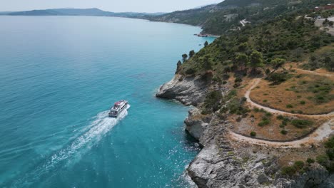 a boat sailing near a coastline with turquoise waters in zante, greece, aerial view