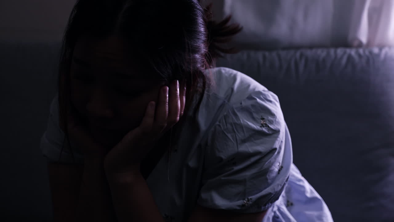 절망으로 머리를 고, 여성은 불안으로 가득 차 있으며 스트레스와 우울증의 징후를 나타니다.