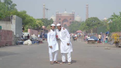 two muslim men hugging each other and smiling at the camera