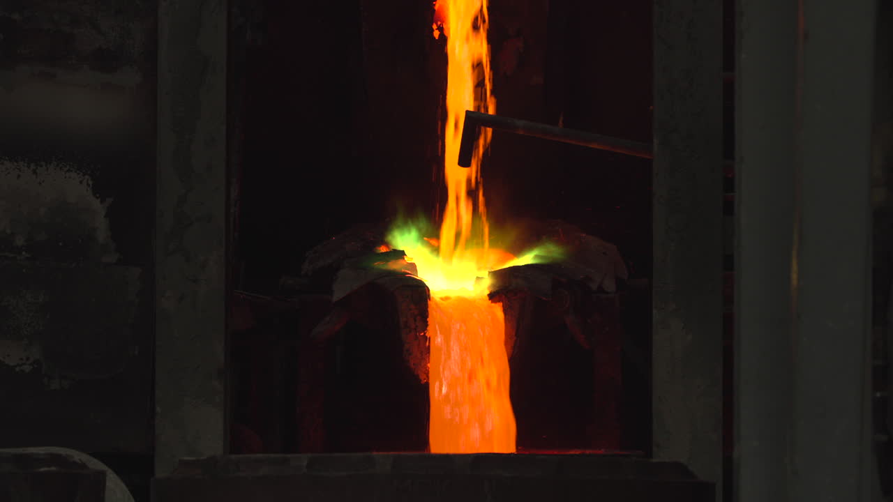 Colata di metallo fuso da un forno in una fonderia