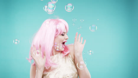 crazy face pink hair woman dancing in bubble showerslow motion photo booth blue background